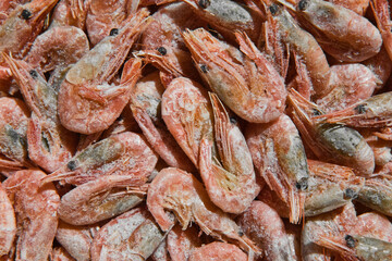Close-up of frozen shrimps. Uncooked and unpeeled seafood background. Boiled and frozen shrimps.