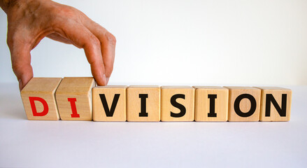 Division or vision symbol. Businessman turns wooden cubes and changes the word 'division' to 'vision'. Beautiful white table, white background. Business, division or vision concept. Copy space.