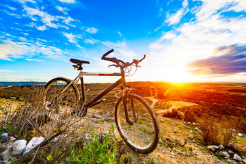 Fototapeta na wymiar Bicicleta de montaña en paisaje de atardecer. Deporte y estilo de vida saludable. Entretenimiento y ocio deportivo