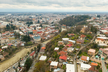 Fototapeta na wymiar General aerial view of Kutaisi cityscape on banks of Rioni River in springtime, Imereti region, Georgia
