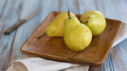 still life, three pears on a wooden plate in rustic style