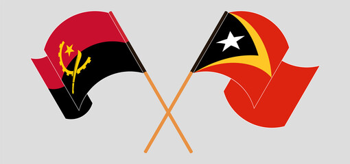 Crossed and waving flags of Angola and East Timor