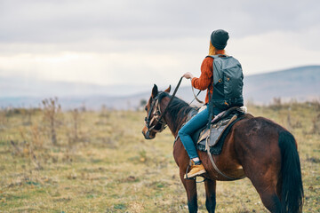 Fototapeta premium woman with backpack riding horse nature walk friendship