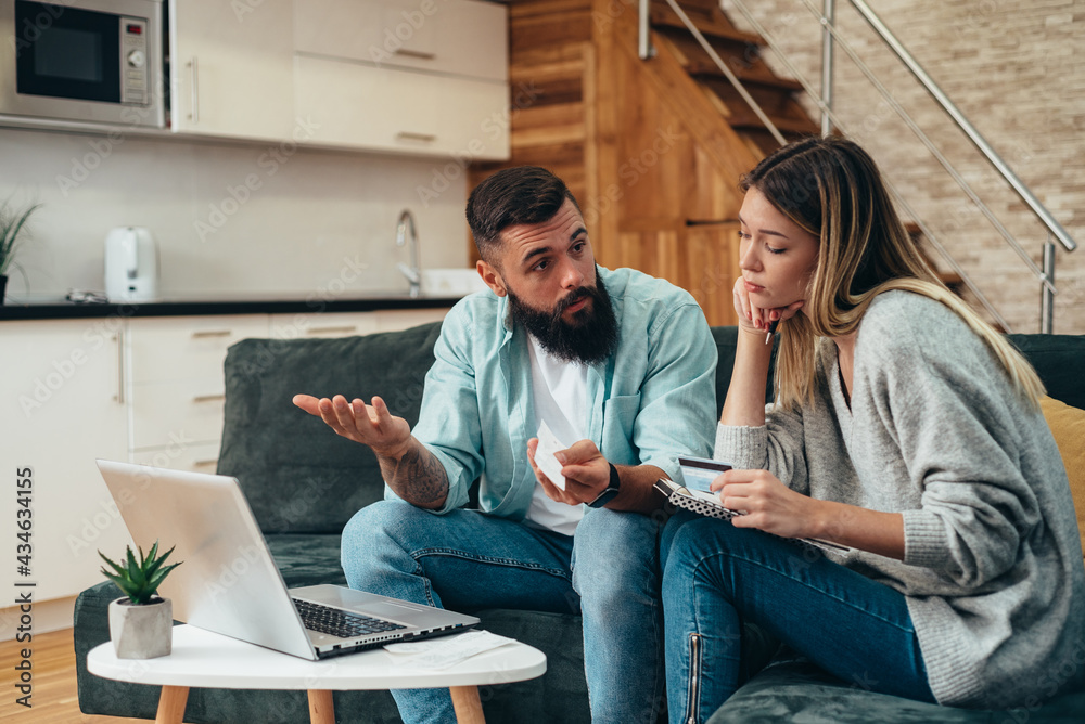 Wall mural couple using a laptop while working on their home finances