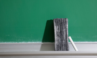 Eraser and chalk on old school chalkboard 
