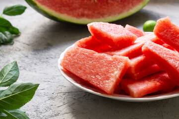 Slice of fresh watermelon in plate on white stone background
