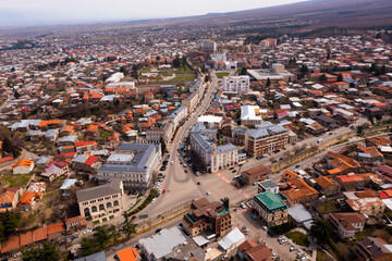 Obraz premium Panoramic aerial view of old Georgian town of Telavi overlooking modern buildings on central street in springtime, Kakheti