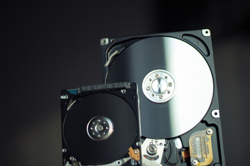 Disassembled hard drive from the computer with mirror effect. Opened hard drive from the computer hard disk drive (HDD)