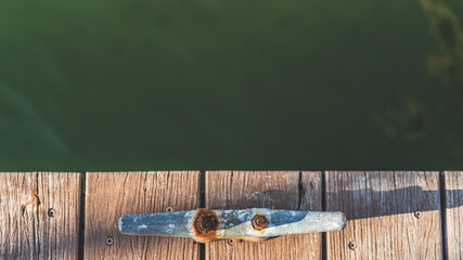 Overhead shot of Rusting mooring cleat on dock with copy space 
