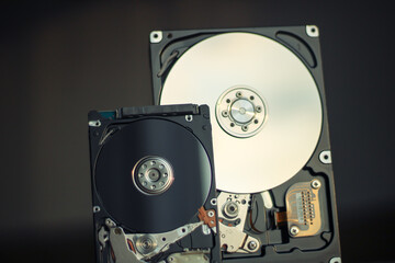 Disassembled hard drive from the computer with mirror effect. Opened hard drive from the computer hard disk drive (HDD)