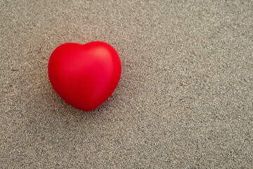 Red heart symbol of love on a rough stone surface. Abstract Saint Valentine background.