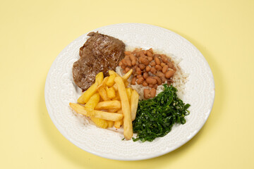 typical Brazilian basic dish with rice, beans, steak, french fries and braised cabbage