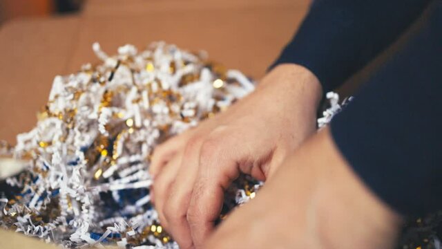 Digging around in a gift box.  Unboxing or gift concept.