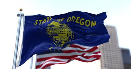 The flags of the Oregon state and United States waving in the wind