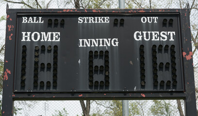 local old and weathered baseball or softball segment outdoor scoreboard with words ball home strike...