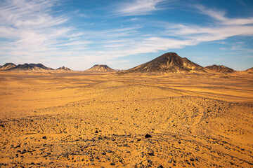 Fototapeta na wymiar Interesting clouds and blue sky above the Black desert, Egypt.