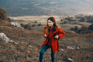 woman in a jacket with a backpack mountains steppe landscape autumn warm clothes model