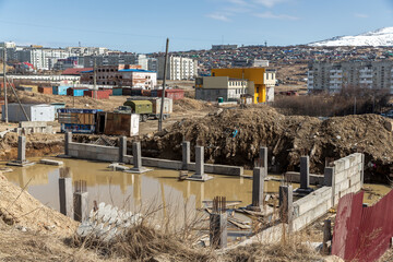 Construction site with flooded foundations and piles. Suspended construction of the building....
