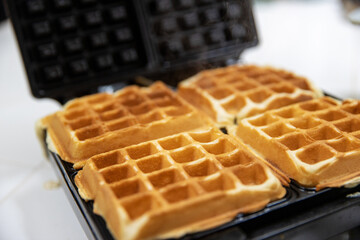 Belgium Waffle cooking on a hot griddle for breakfast