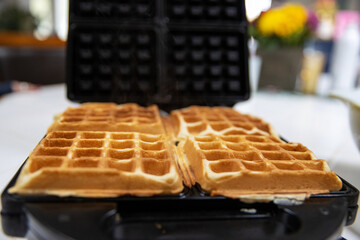 Belgium Waffle cooking on a hot griddle for breakfast