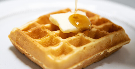 Hot Belgium Waffle drizzled with maple syrup for breakfast