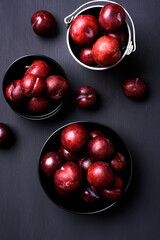 Japanese or Chinese red plum fruit in a bowl on black background, Top view