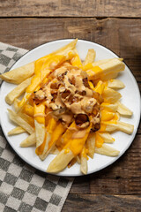 Animal style fries with cheese and caramelized onion on wooden background