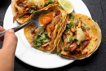 Pork tacos called al pastor with pineapple on dark background. Mexican tacos