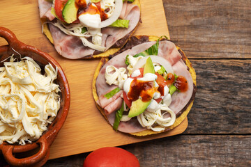 Corn toast with ham and Oaxaca cheese on wooden background. Mexican food