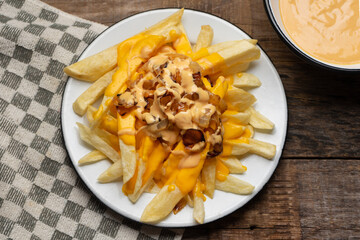 Animal style fries with cheese and caramelized onion on wooden background