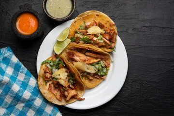 Pork tacos called al pastor with pineapple on dark background. Mexican tacos