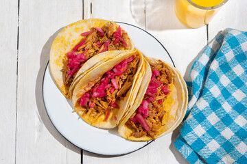 Pork tacos called cochinita pibil with purple onion on white background. Mexican tacos