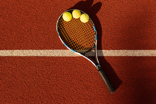 Tennis Ball with Racket on the racket in tennis court