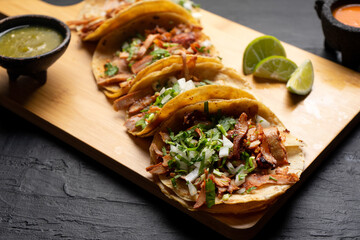 Pork tacos called al pastor with pineapple on dark background. Mexican tacos