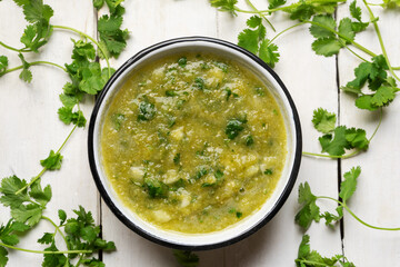 Mexican piquant green sauce with cilantro and onion on white background
