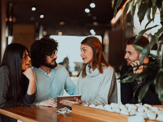 A group of friends hanging out in a cafe, and talking about business