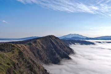 青空の下の雲海と山の稜線の景観。日本の北海道の摩周湖。