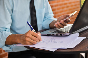 Close up hand  pen writing paperwork, Businessman work computer technology