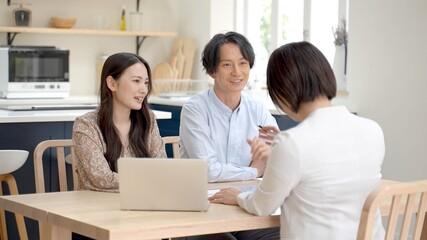 家で打ち合わせをするビジネスウーマンと夫婦