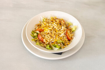 Mixed scrambled and not very showy salad with chunks of tomato, onion, lettuce