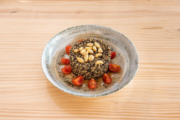 Black and white quinoa salad with nuts and cherry tomatoes