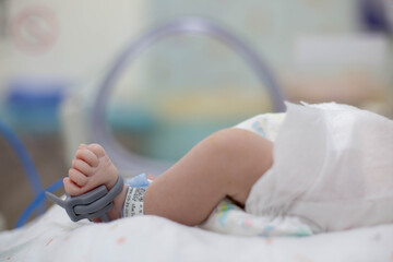 Foot of Asian newborn baby in the delivery room at hospital. In the newborn incubator is A medical device used to regulate the temperature of a newborn baby to be healthy according to the criteria