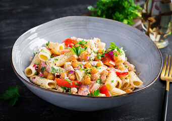Vegetarian vegetable pasta. Pasta rigatoni with tomato, red onion, parsley and fried chickpeas with nut sauce. Vegan food.