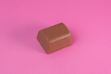 Obraz na płótnie Canvas Brown chocolate bar on the pink background