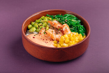 Hawaiian shrimp poke bowl with vegetables on purple background