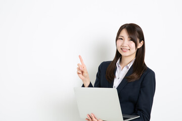 パソコンを持って指差ししているビジネスウーマン