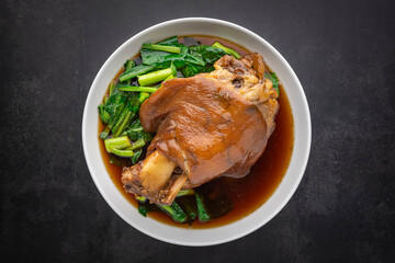 Kha Moo Pa Lo, Thai food, brown Chinese stewed pork leg in sweet brown sauce on dark tone texture background, top view shot