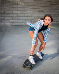 Young Woman Riding a Skateboard in an Urban Area with space for copy 
