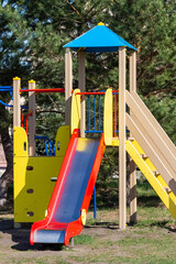 Colored children's slide for small children in a rural park.