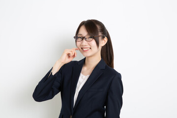 Fototapeta premium 指を頬にあてて笑っているメガネのビジネスウーマン